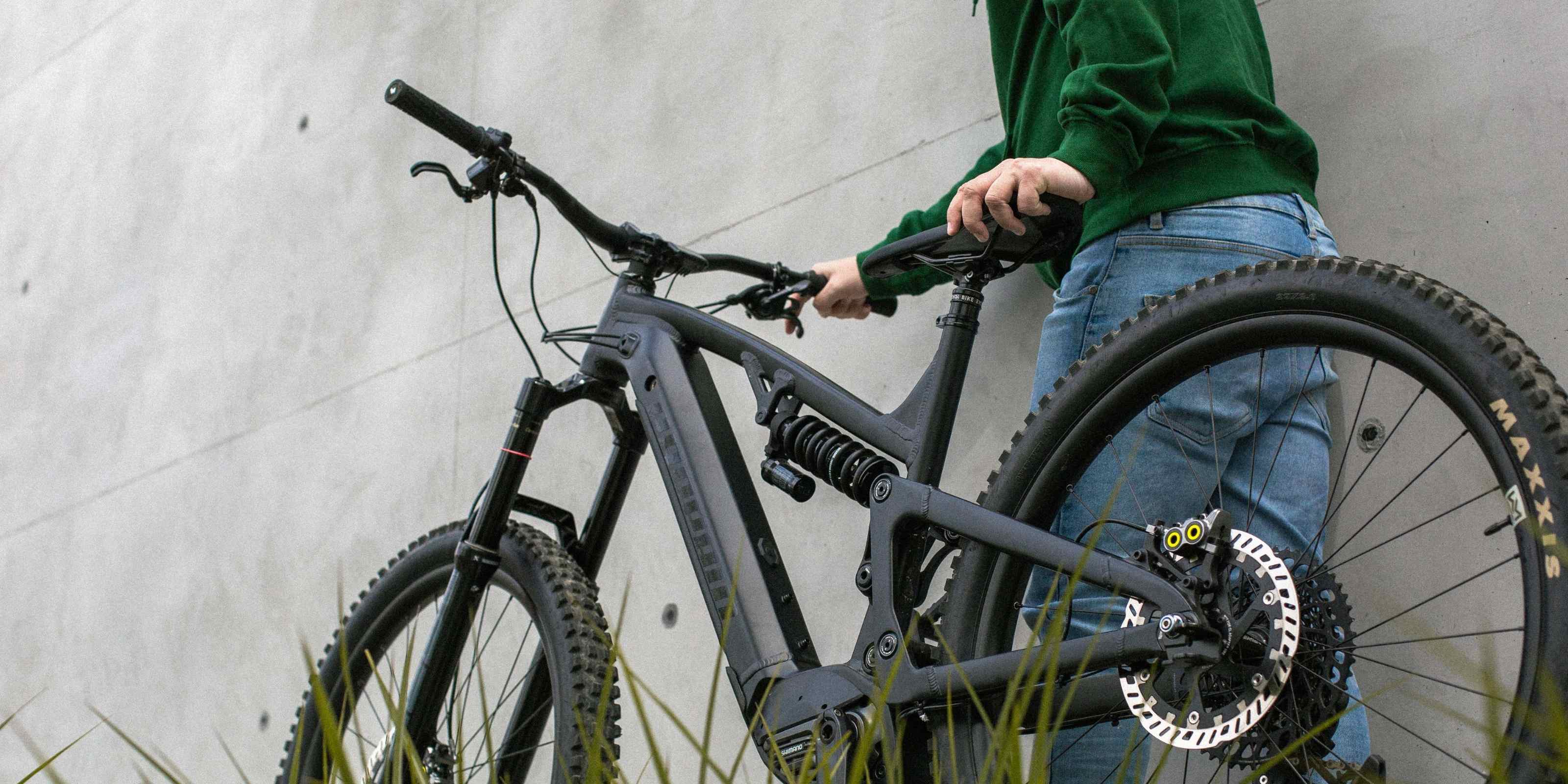 Person mit schwarzem E-Bike, Akku Life Guard schützt Alltagsgeräte, Nachhaltigkeit und Schutz im Fokus