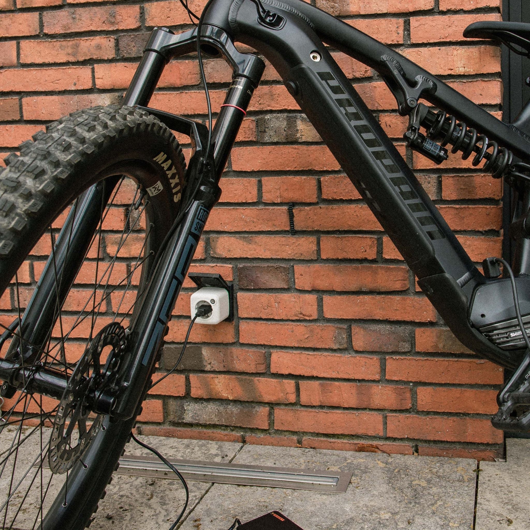 E-Bike vor Backsteinwand, Akku Life Guard angeschlossen für geschützten Ladevorgang