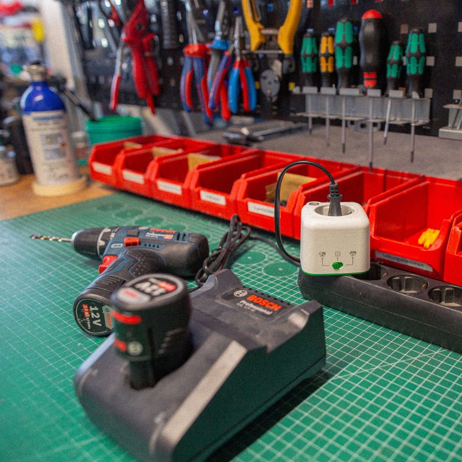 Werkstatt mit Bosch Akkuschrauber und Ladegerät, Akku Life Guard sorgt für sicheres Laden, Werkzeugwand im Hintergrund